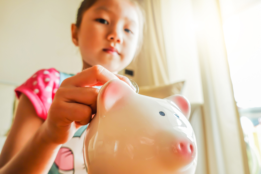 저금통에 동전을 넣는 아이 손